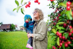 Tagesmutter Cathrin Daubenberger mit einem Tageskind im Garten in Gräfenhausen - Fotoprojekt Nur-so-halb von Stefanie Morlok Fotografin